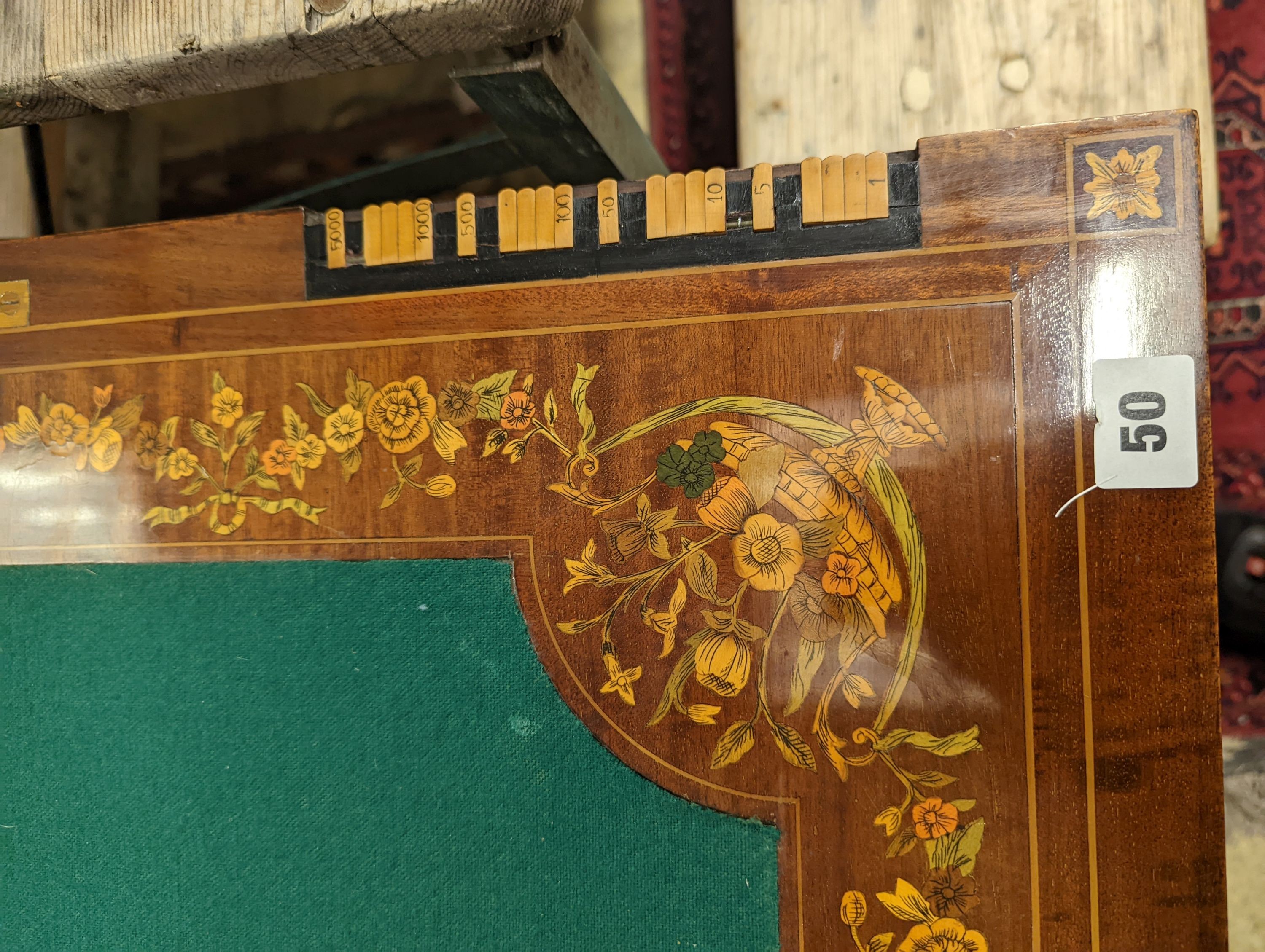 An Edwardian marquetry inlaid mahogany folding games table by W. Thornhill & Co., London, the interior baize lined surface with cribbage board and hinged markers, width 76cm, height 76cm